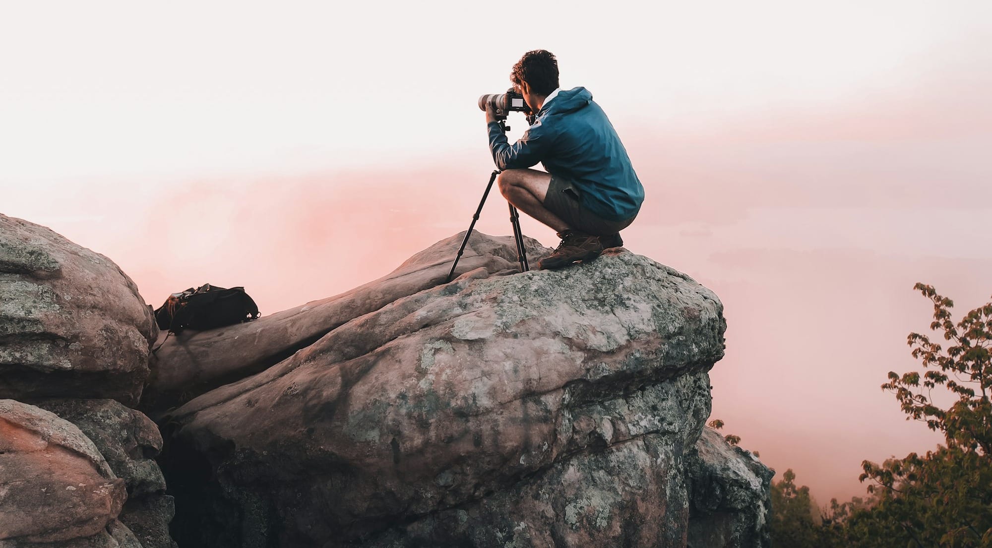 man using telescope white standing on mountain edge