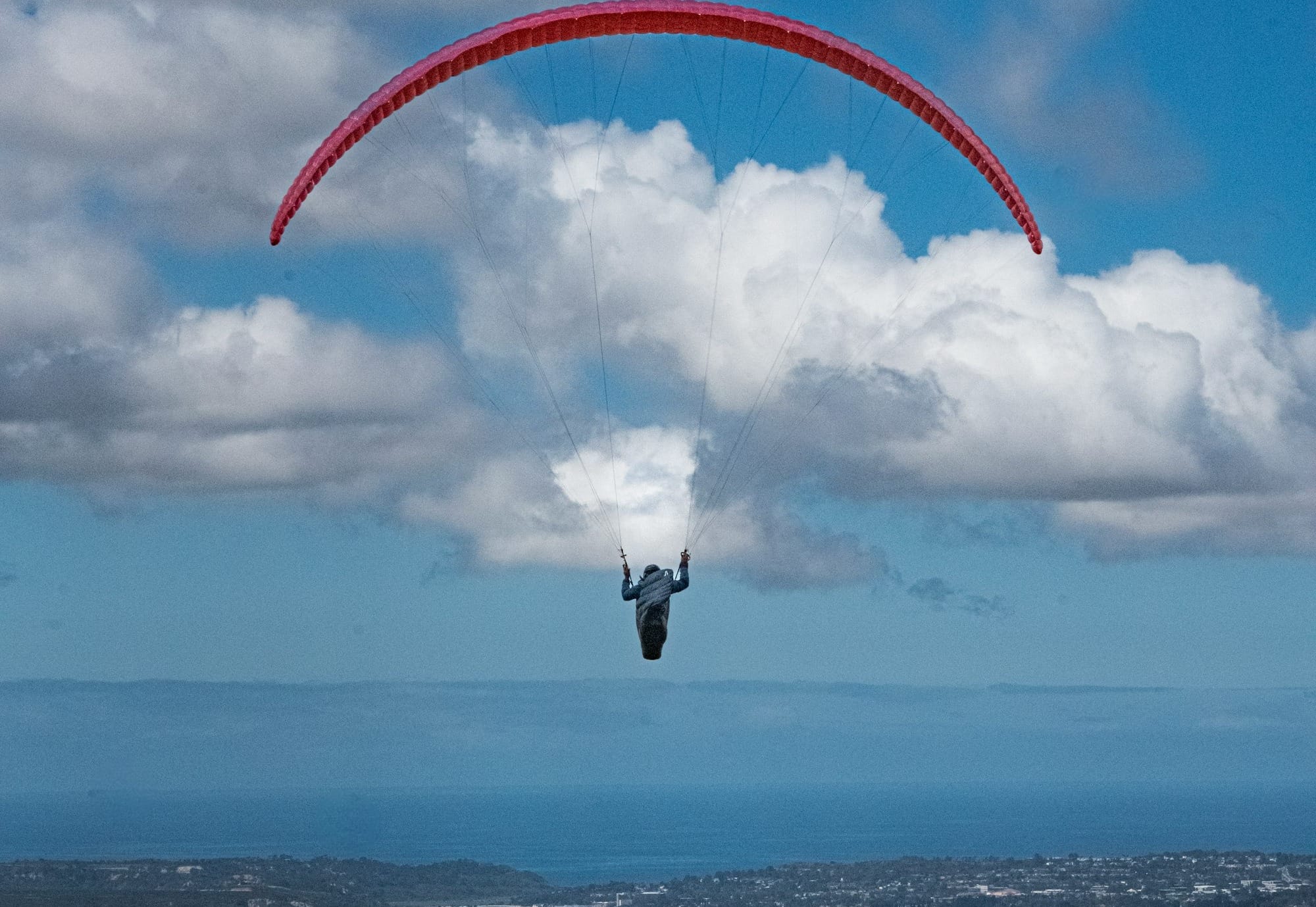 a person is parasailing in the sky above a city