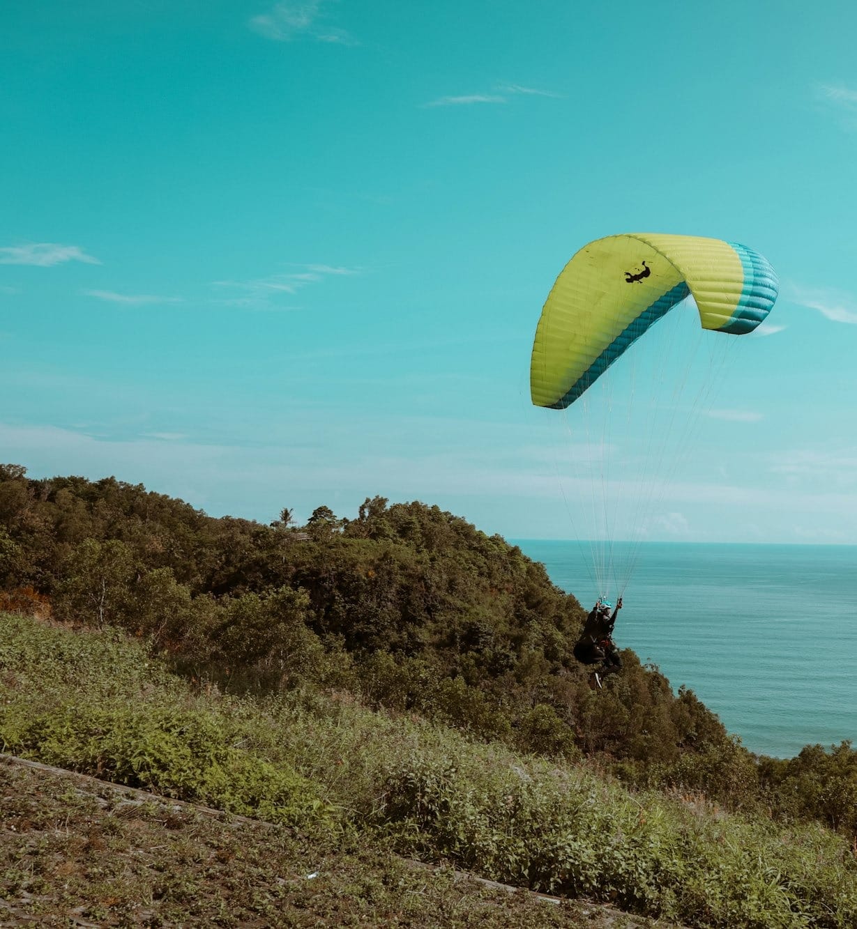 yellow and green parachute over the sea during daytime